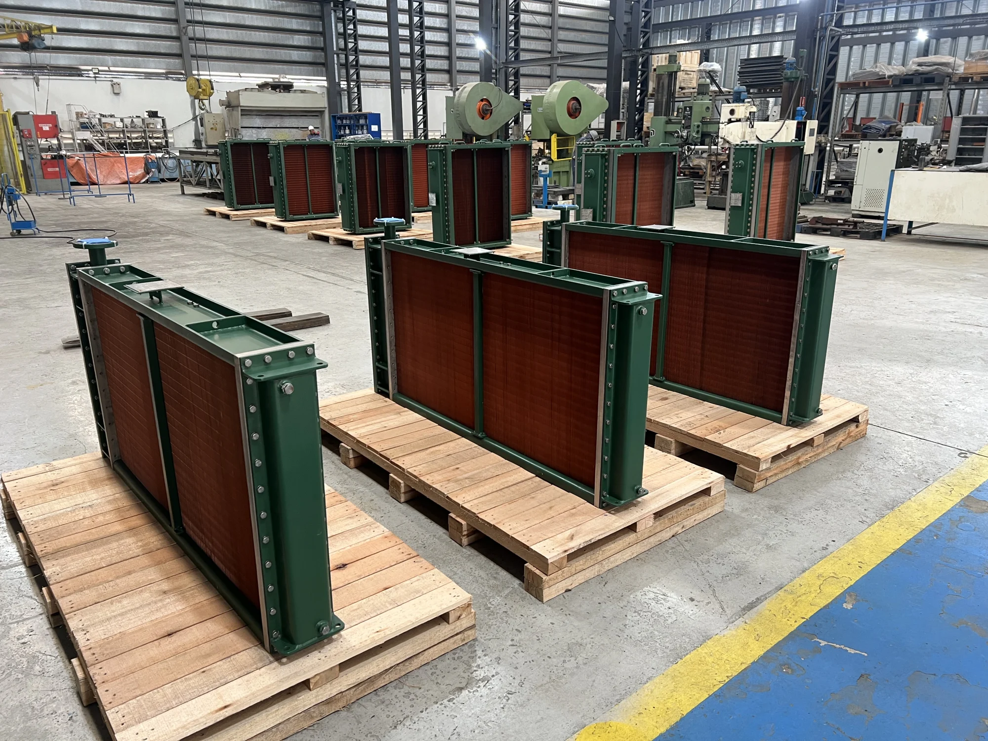 Radiadores industriais TWT sobre pallets no chão de fábrica